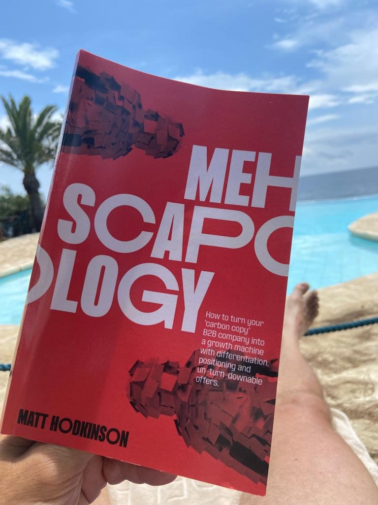 Reader of MEHscapology (written by Matt Hodkinson) holding book by the poolside
