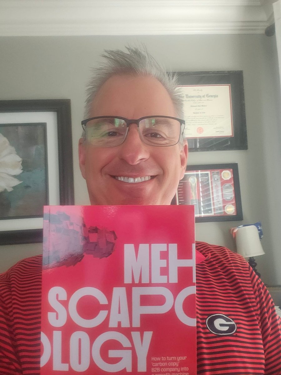 Smiling reader holding up MEHscapology book, written by Matt Hodkinson